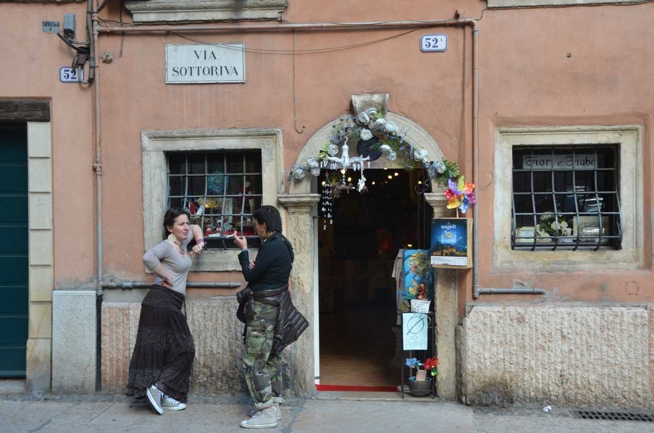 Adige Nehri kenarındaki Via Sottoriva’da arkadaşı ile çene çalan dükkân sahibi veya çalışanı…